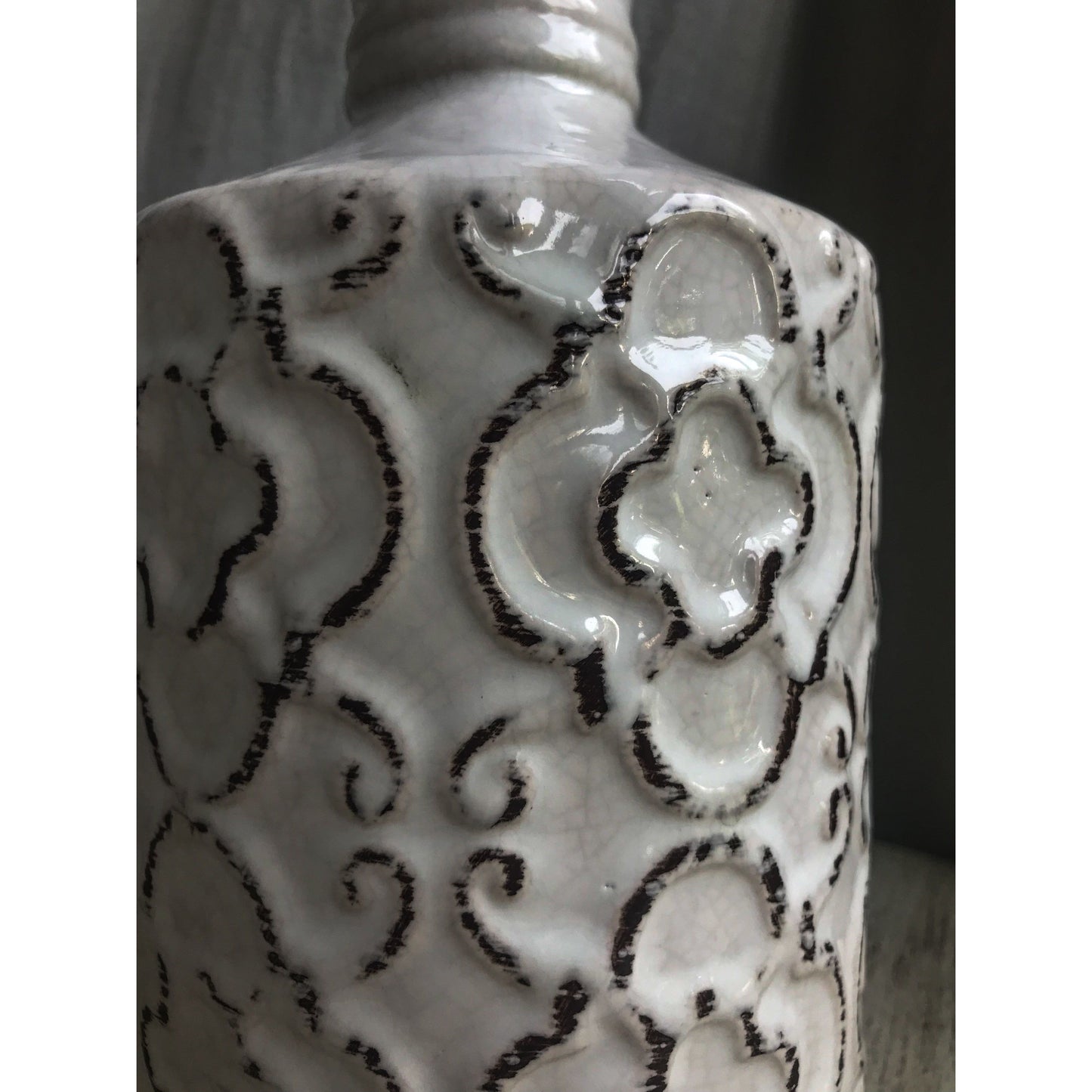 An ornate decorative vase with a classic urn shape, featuring intricate black metallic patterns on a white background