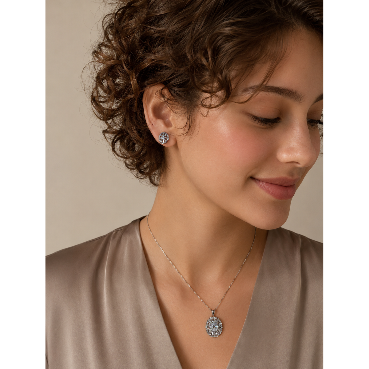 Woman wearing silver floral crystal pendant necklace and matching stud earrings with detailed circular design and sparkling stones.