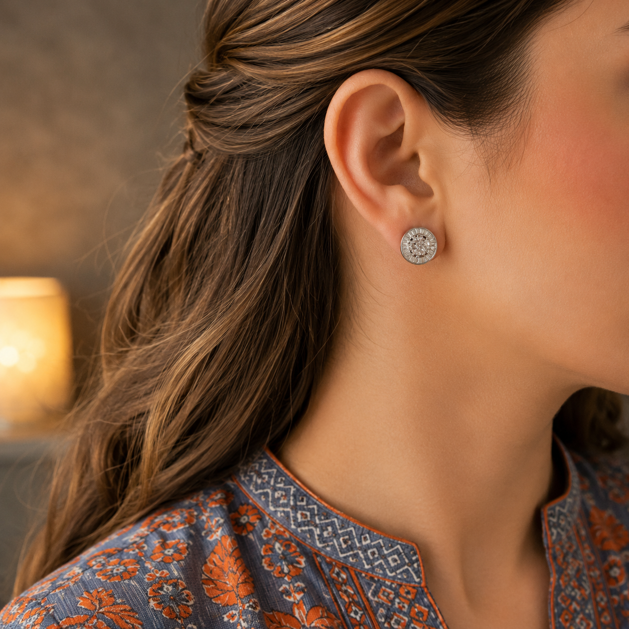 Woman wearing round mosaic crystal stud earrings with a slate blue and orange printed linen shirt in a close-up portrait.