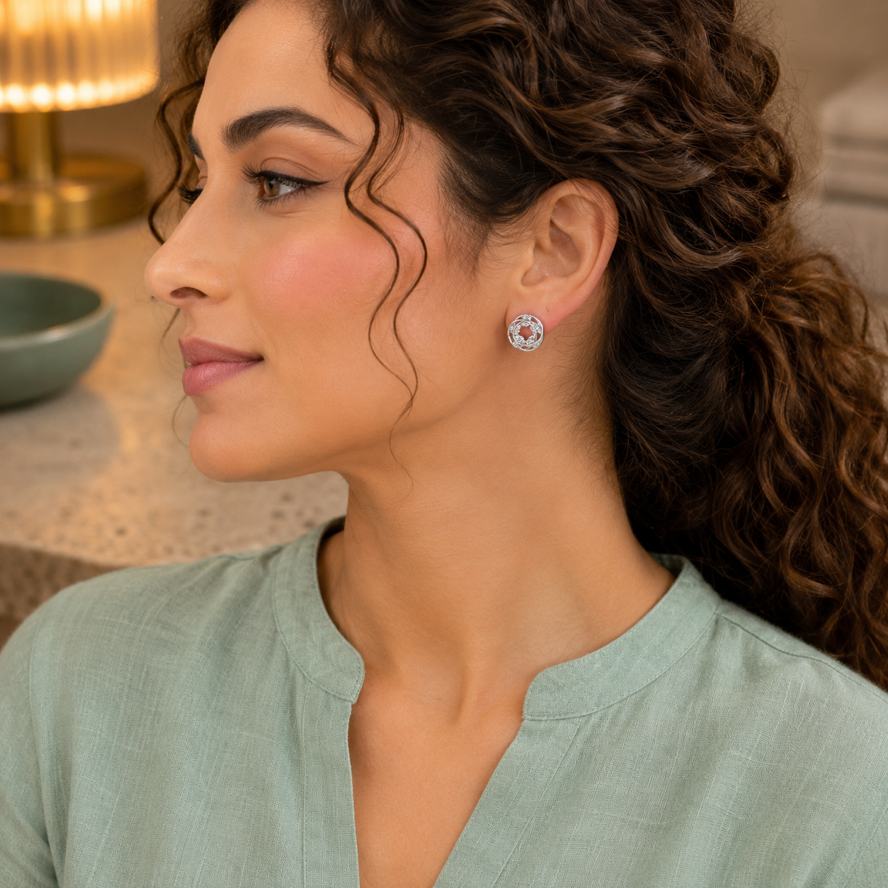 Woman wearing silver interlocking circle zircon stud earrings with a sea green linen kurta in a luxury indoor setting, showcasing modern everyday jewellery.