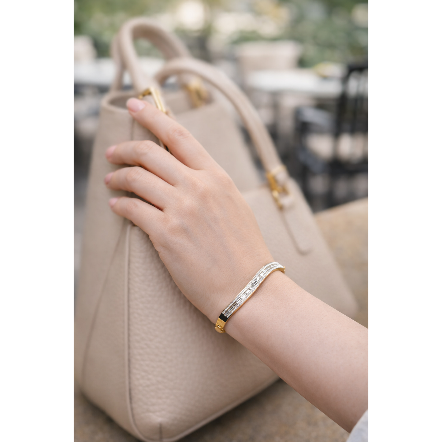 Gold-tone crystal lock bracelet worn on wrist with beige handbag, stylish everyday fashion jewelry