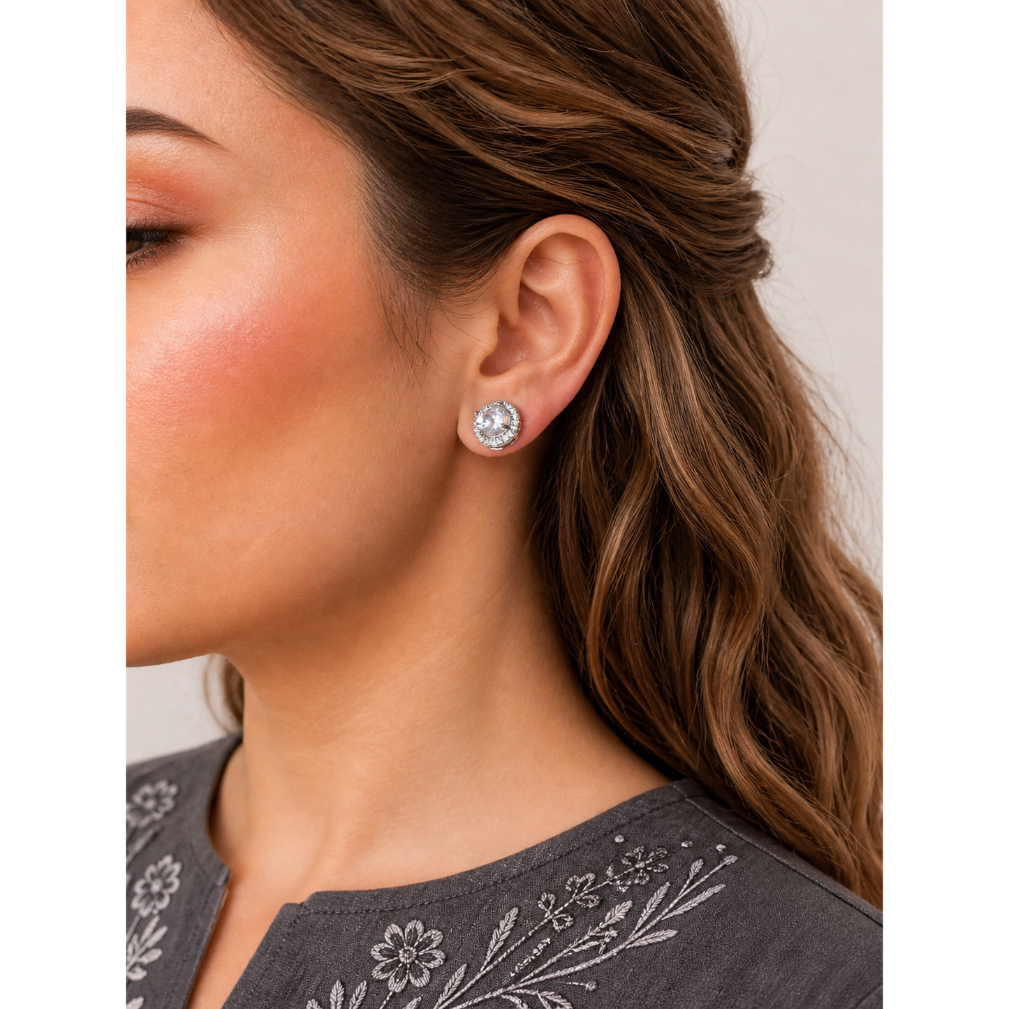 Round halo crystal stud earrings worn on ear showing central zircon stone with surrounding sparkle