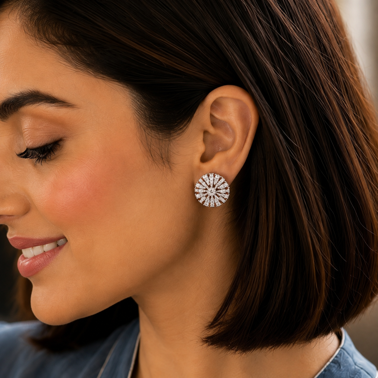Close-up of blue floral crystal stud earrings on a model's ear, highlighting the intricate stone arrangement.