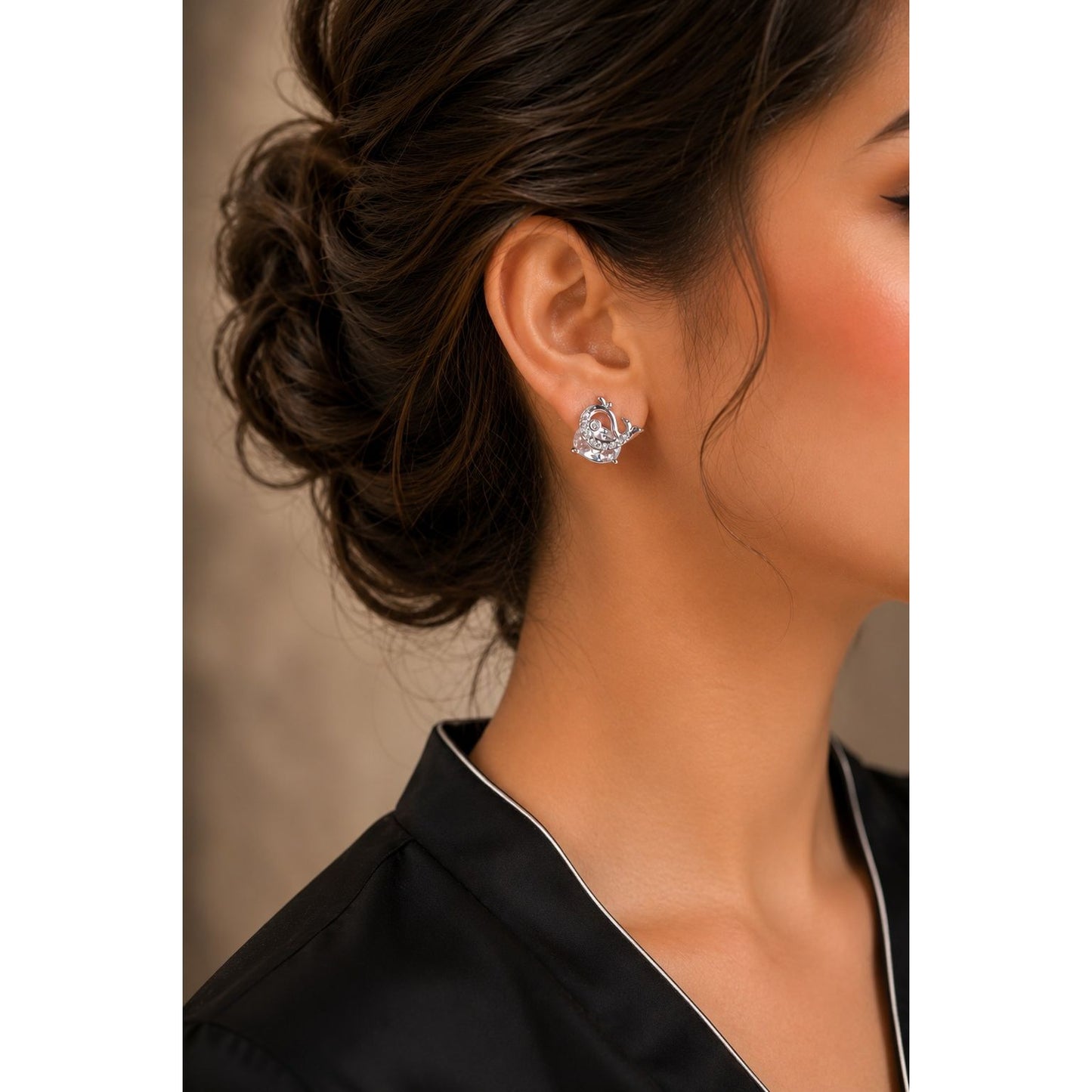 Woman wearing premium silver crystal whale stud earrings with sparkling cubic zirconia in a luxury side-profile portrait.