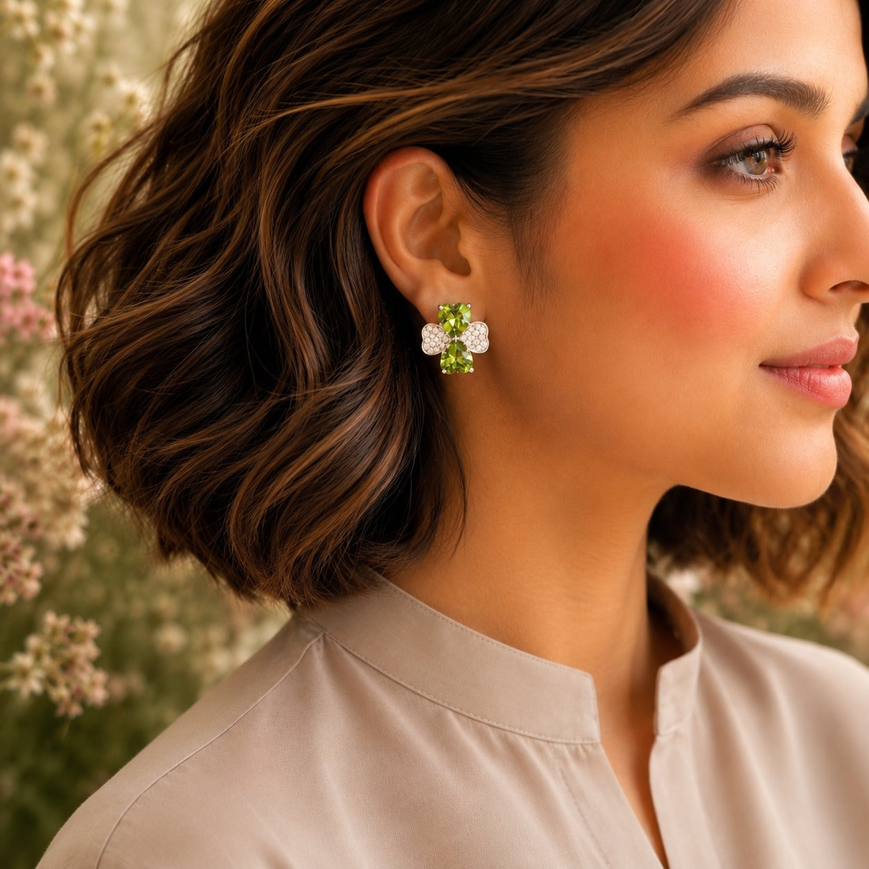 Model wearing silver crystal bow stud earrings with peridot green heart-cut crystals.