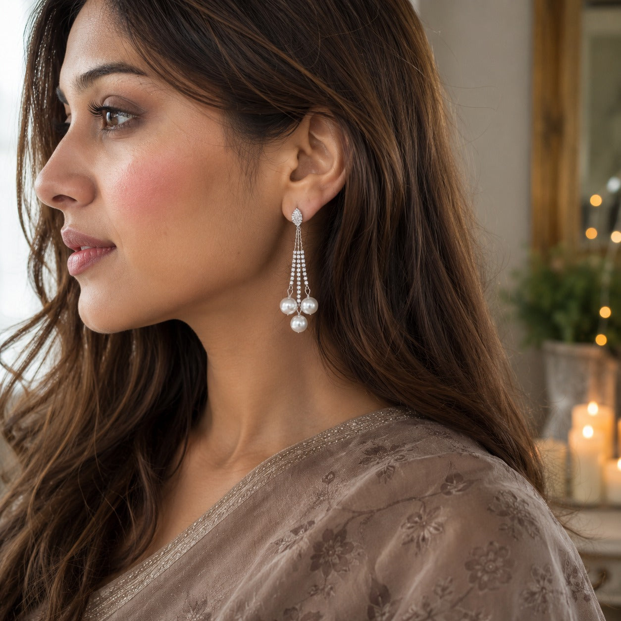 Woman wearing elegant silver crystal tassel earrings with three pearl drops in a luxury side-profile portrait