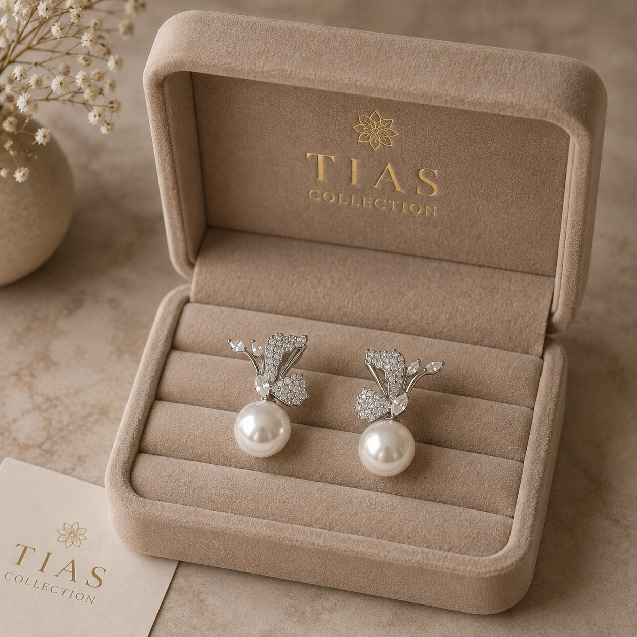 Statement pearl drop earrings featuring sculptural silver-tone curves, sparkling clear zircon and botanical wing-like detailing.