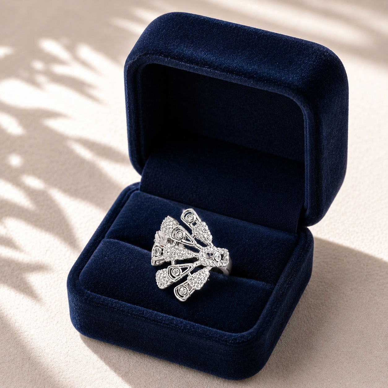 Silver statement ring presented in a deep navy velvet jewellery box, highlighting its intricate fan-shaped zircon design.