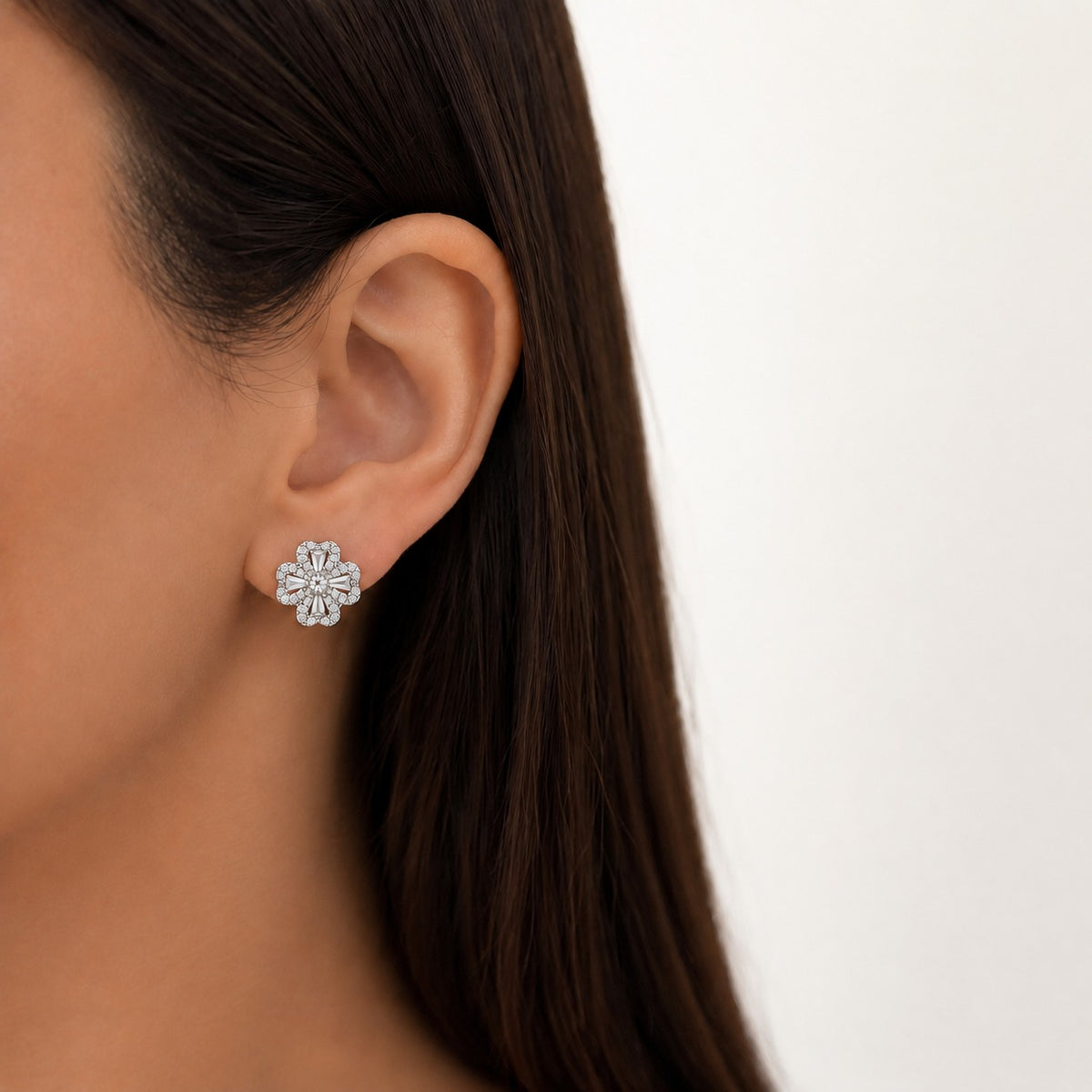 Model wearing an S925 silver Prism Clover Stud, showing the compact four-petal design and sparkling clear zircon details on the ear.