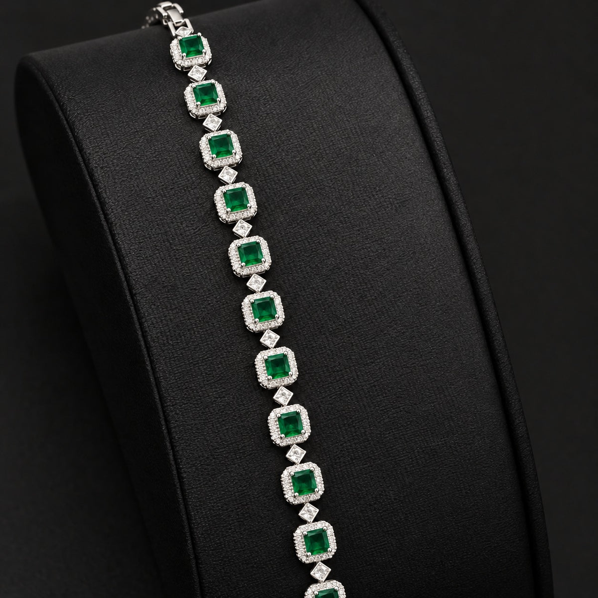 Silver-tone Regal Grid Bracelet featuring square-cut green gemstones surrounded by clear zircon borders and connected with small diamond-shaped zircon links, available in ruby red, emerald green and clear zircon.