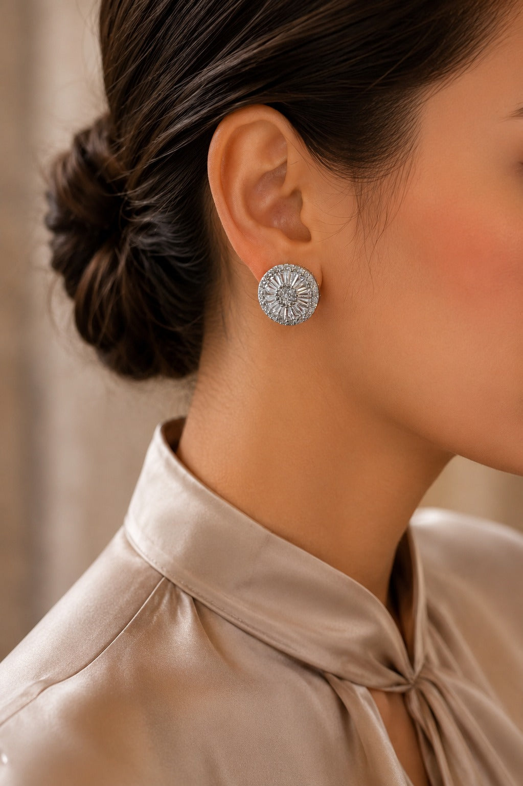 Model wearing radiant silver-tone halo crystal stud earrings with a circular sunburst design, styled with a champagne satin blouse for a refined everyday and occasion look.