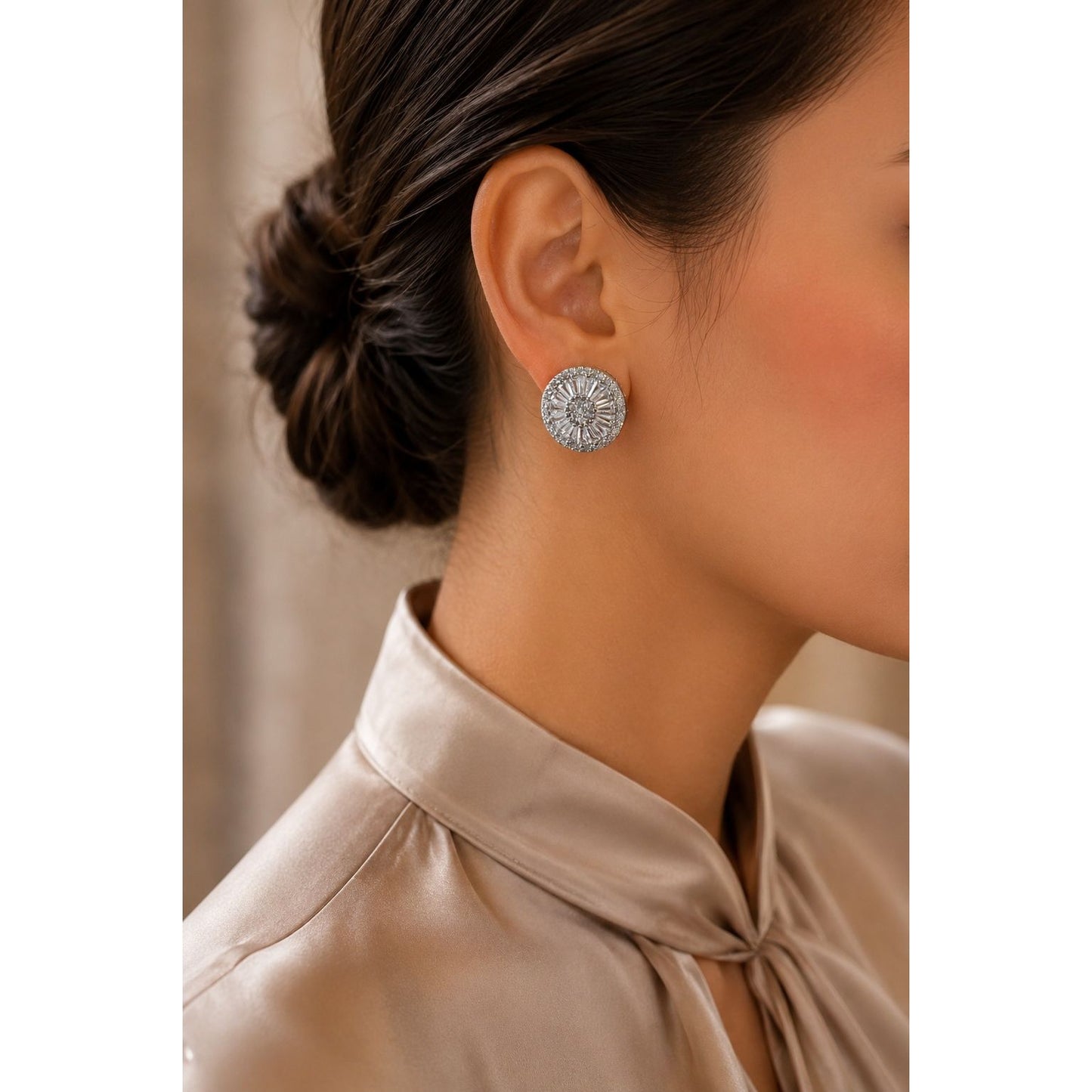 Model wearing radiant silver-tone halo crystal stud earrings with a circular sunburst design, styled with a champagne satin blouse for a refined everyday and occasion look.