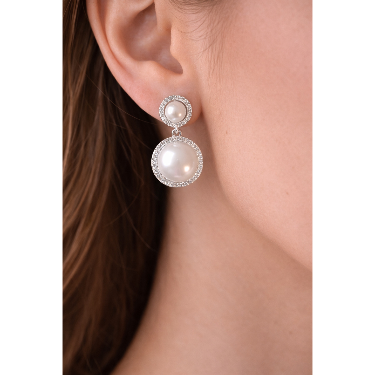 Close-up of pearl drop earrings with crystal accents worn on a model’s ear, showcasing elegant feminine jewellery styling.