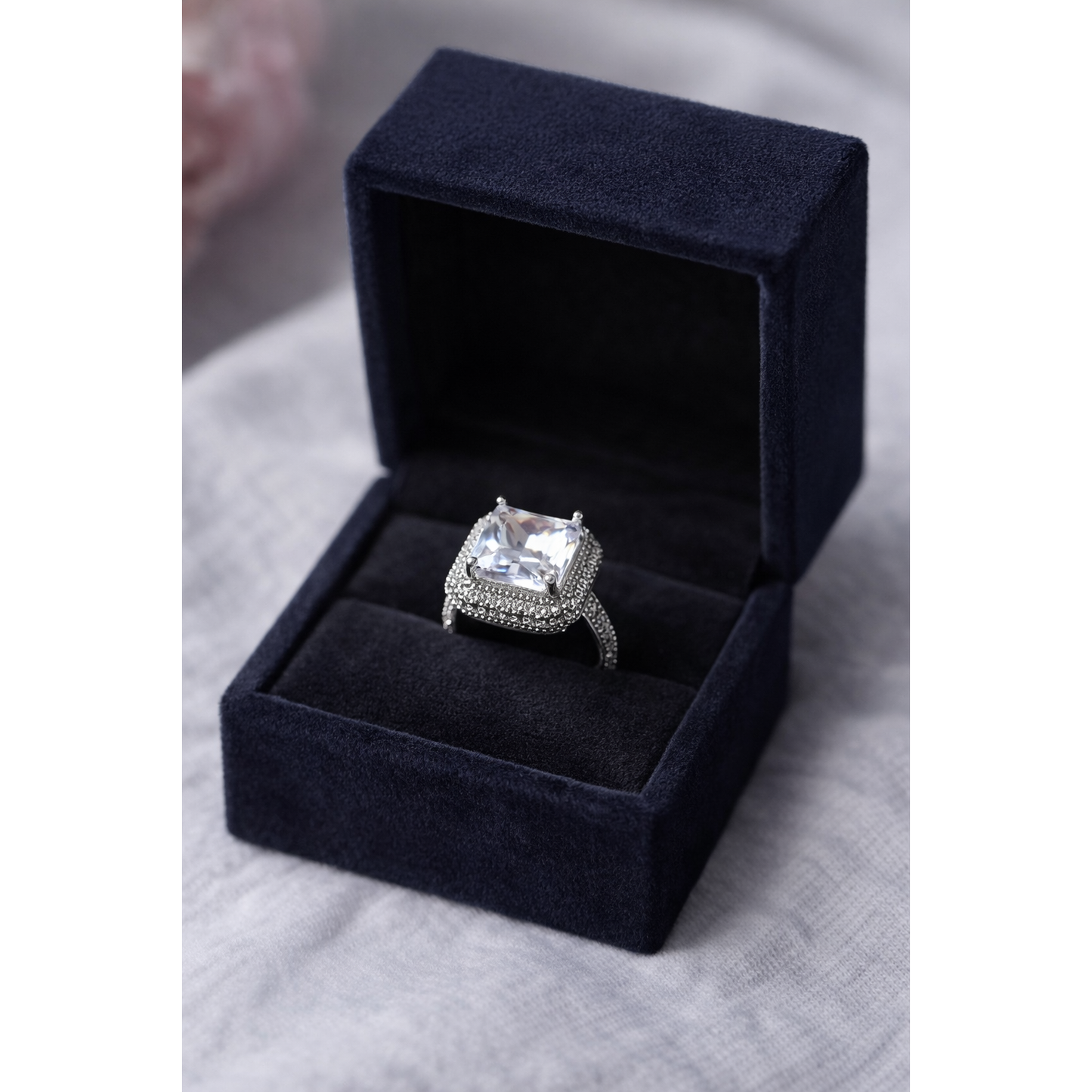 Diamond ring in a black velvet box on a gray surface