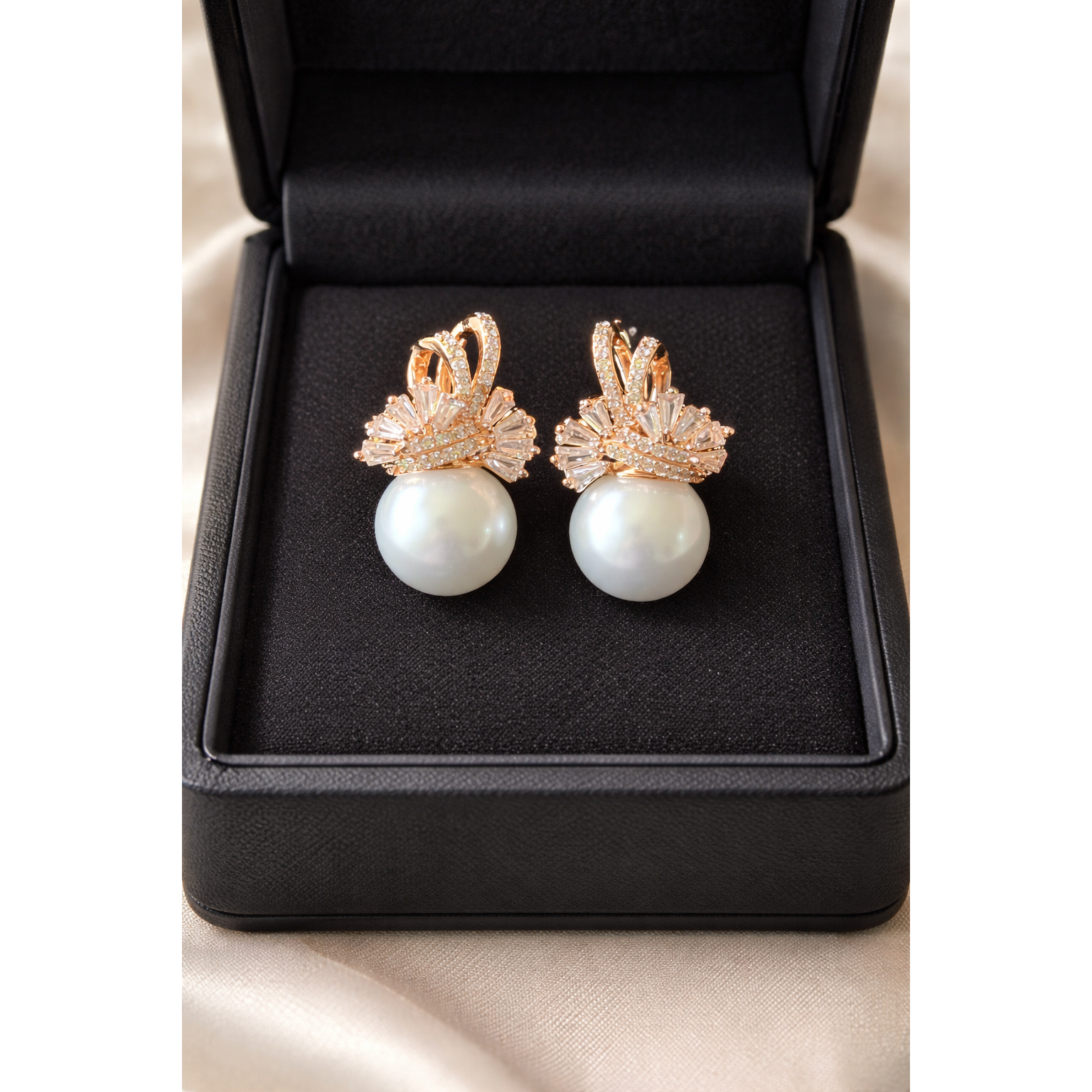 TIAS pearl drop earrings with crystal detailing in gold finish displayed inside a black jewelery box.