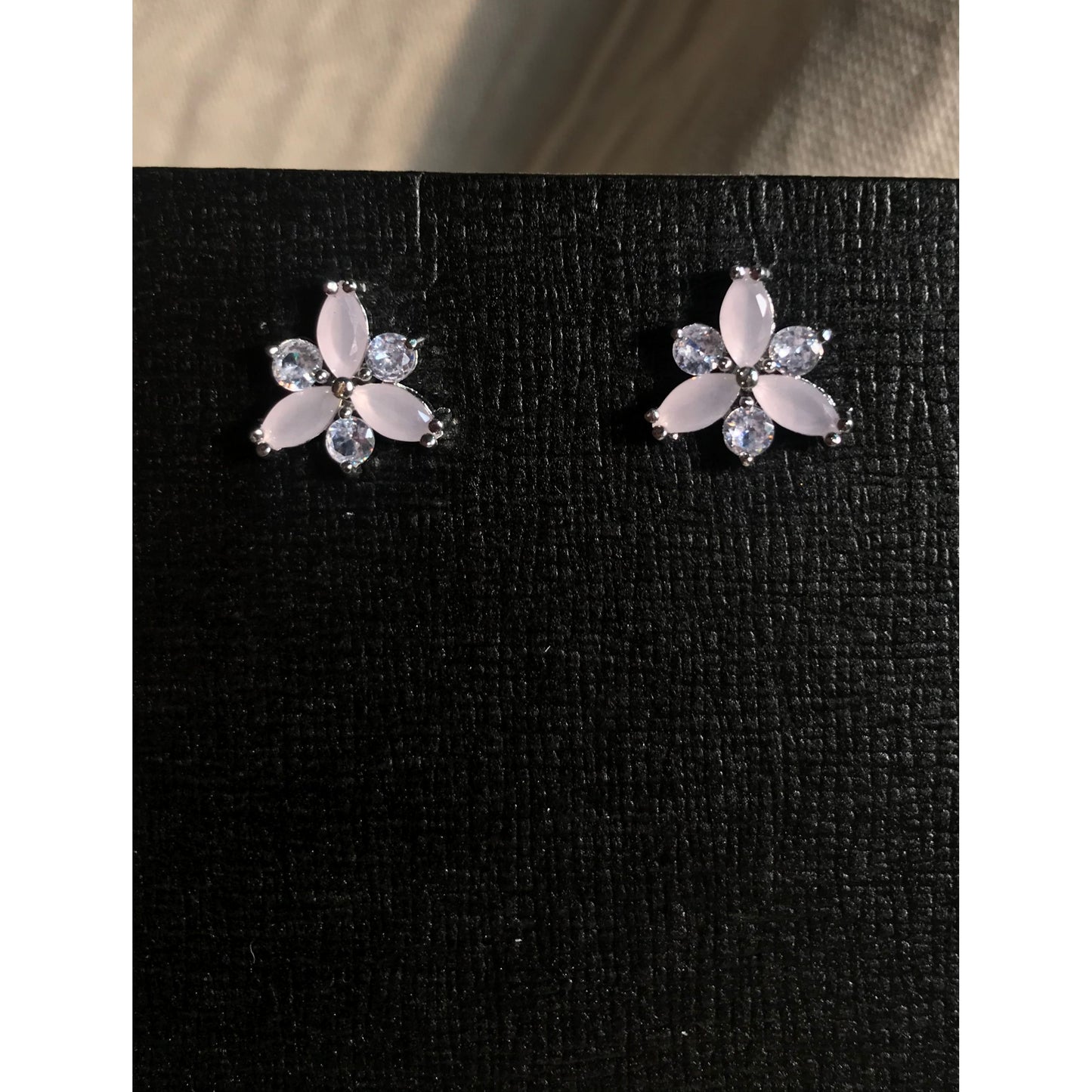 Flower-shaped earrings with gemstones on a black background