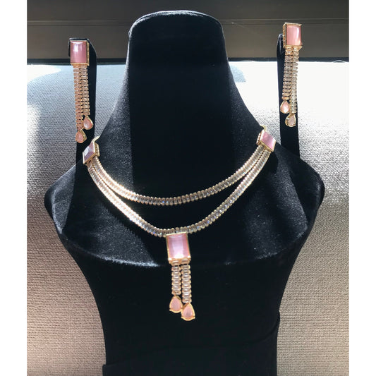 Gold-plated necklace set with pink rectangular stones, dual crystal beaded chains, and matching drop earrings with pear-cut pink stone accents.