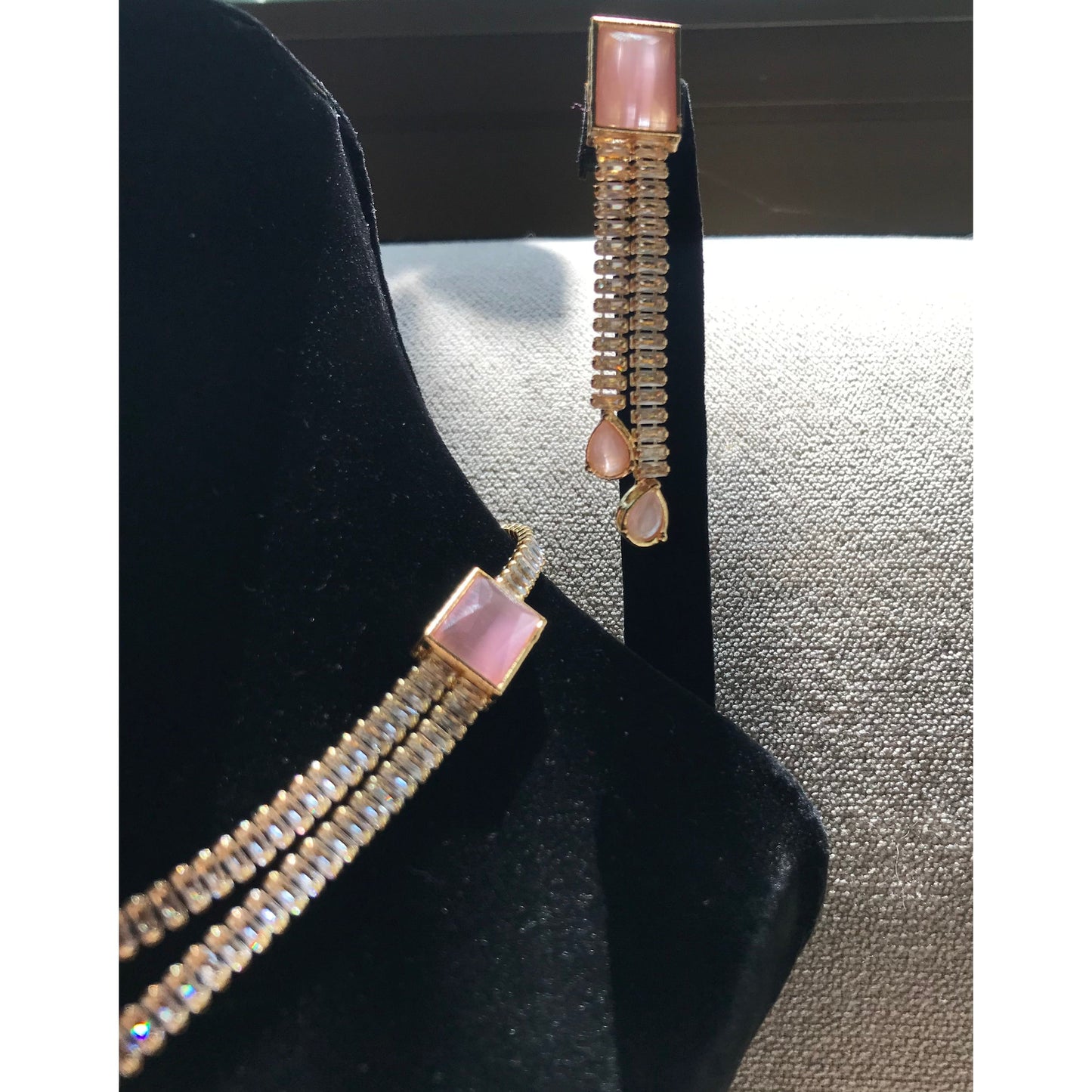 Gold-plated necklace set with pink rectangular stones, dual crystal beaded chains, and matching drop earrings with pear-cut pink stone accents.