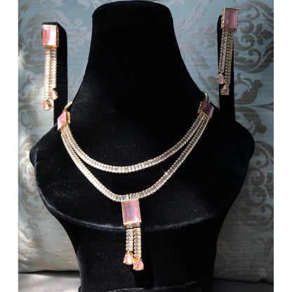 Jewelry set with necklace and earrings on a black mannequin against a decorative wall.