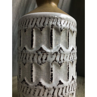 A two-tone ceramic vase with a gold top and a white bottom featuring a dark-outlined embossed quatrefoil pattern.