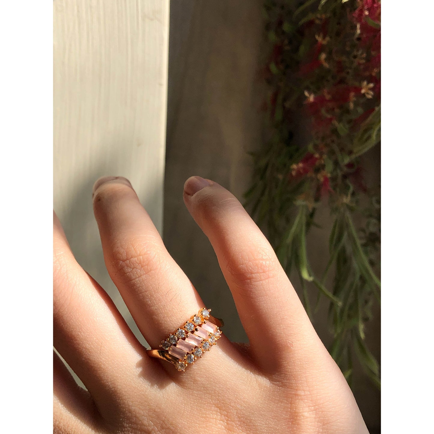 A close-up of a slender ring band completely covered in small, sparkling clear cubic zirconia stones, displayed on a reflective surface.