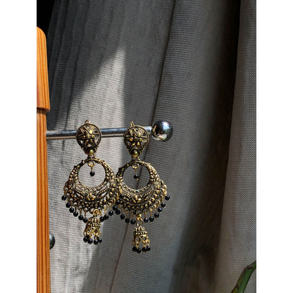 A collection of traditional jhumka earrings, featuring ornate bell shapes with intricate filigree details and various colorful accents like blue enamel or small dangling beads.