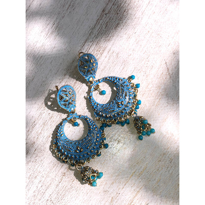 A collection of traditional jhumka earrings, featuring ornate bell shapes with intricate filigree details and various colorful accents like blue enamel or small dangling beads.