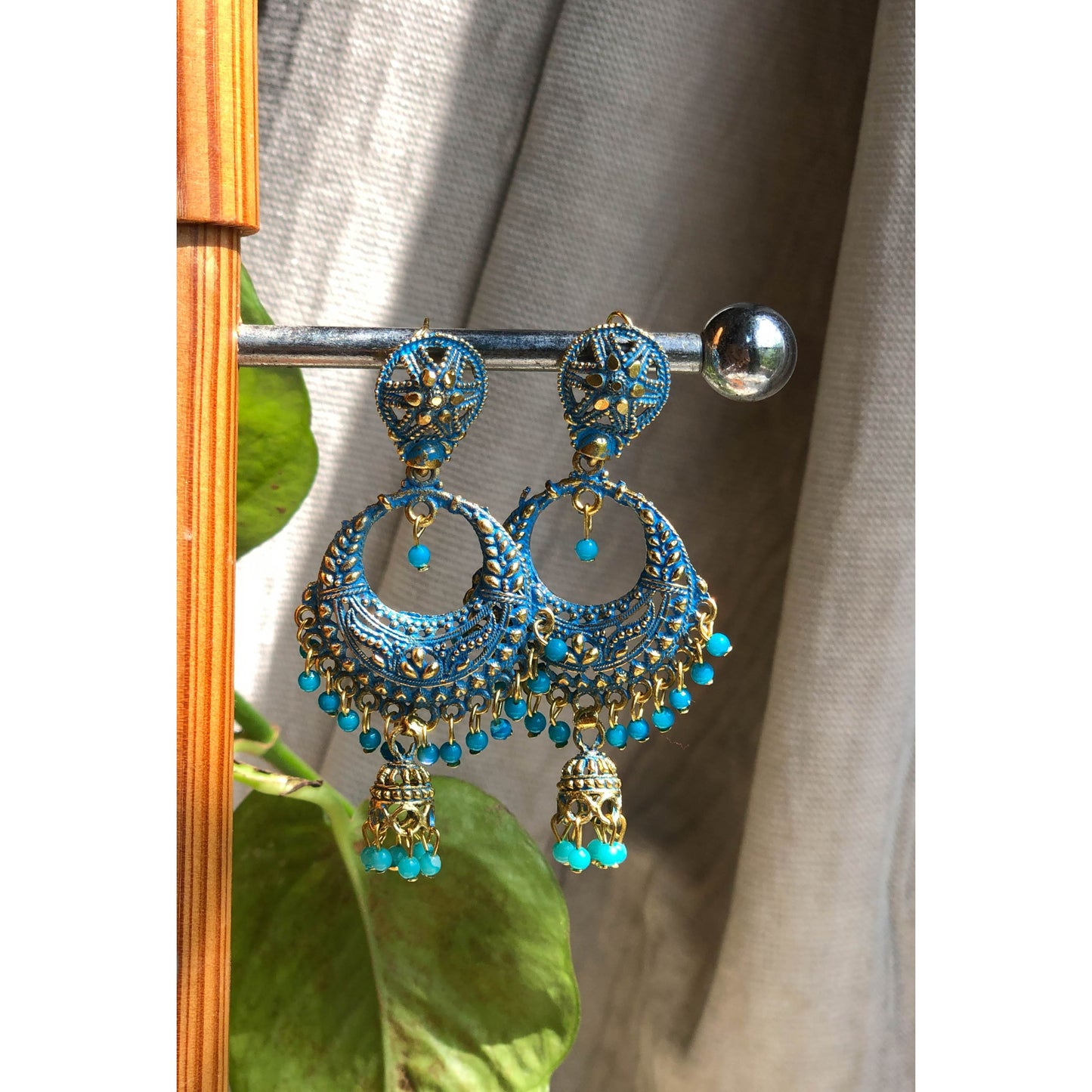 A pair of ornate silver-tone chandbali jhumka earrings featuring a crescent moon design at the top with intricate patterns and a dangling bell-shaped jhumka at the bottom.