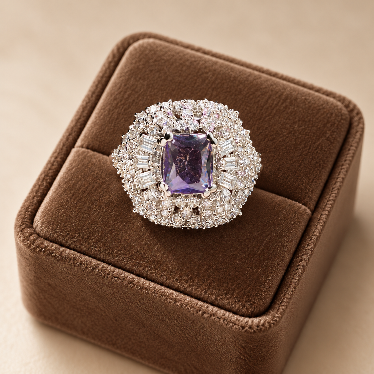 Close-up of the Amethyst Imperial Crest Ring showcasing its purple rectangular-cut gemstone, baguette-cut zircon accents and intricate silver-tone setting on mocha velvet