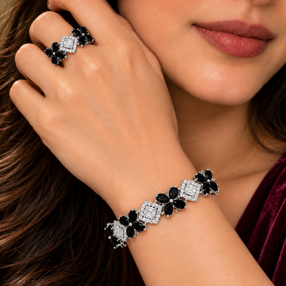 Woman wearing a jet black floral bracelet and matching ring, featuring brilliant zircon centrepieces and delicate flower-shaped gemstones.