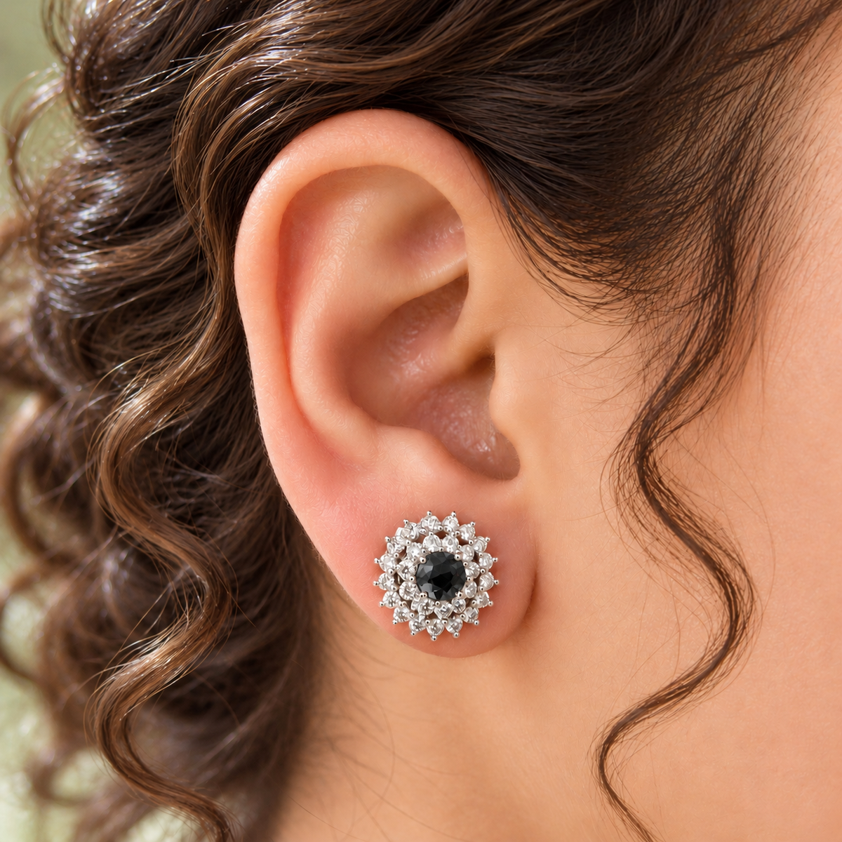 Close-up of a woman's ear wearing a black Kensington Cluster Stud, showcasing its delicate circular design and neat placement on the earlobe. 