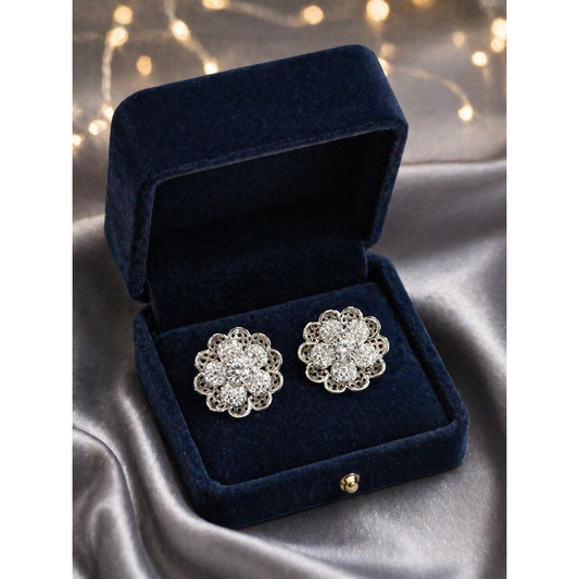 Silver floral crystal stud earrings placed in premium velvet jewelry box on satin background with soft lighting