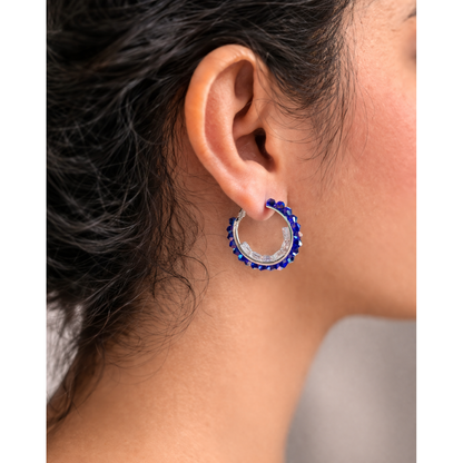 Woman wearing blue beaded silver hoop earrings close up side view