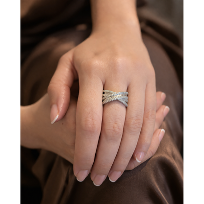 Adjustable silver statement ring worn on finger showing layered crisscross design with sparkling zircon stones in soft warm lighting