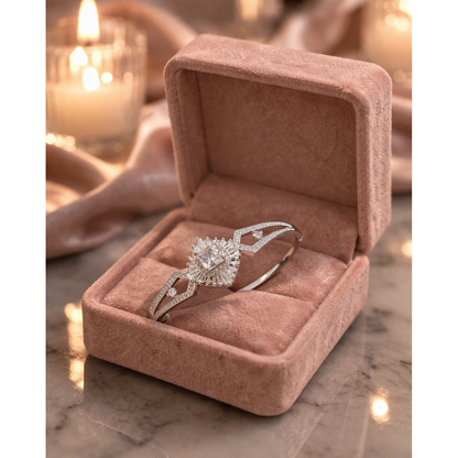 Silver crystal bracelet with lock placed in soft pink velvet jewelry box on marble surface with warm candle background