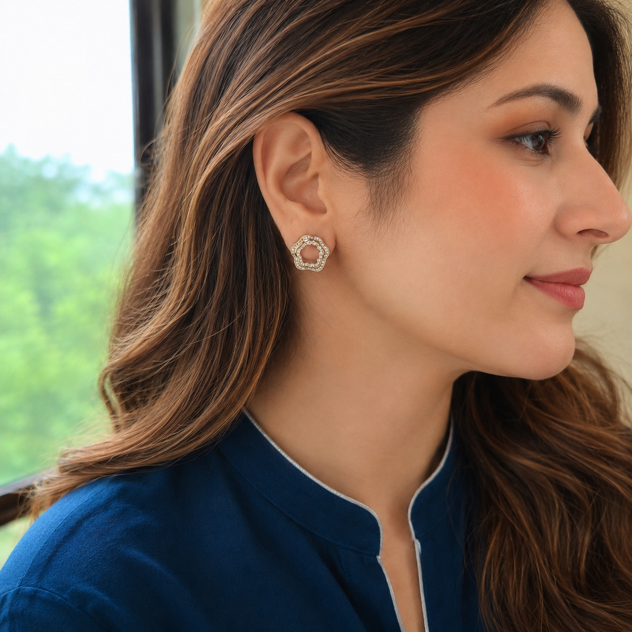Woman wearing gold open-centre petal zircon stud earrings with navy outfit