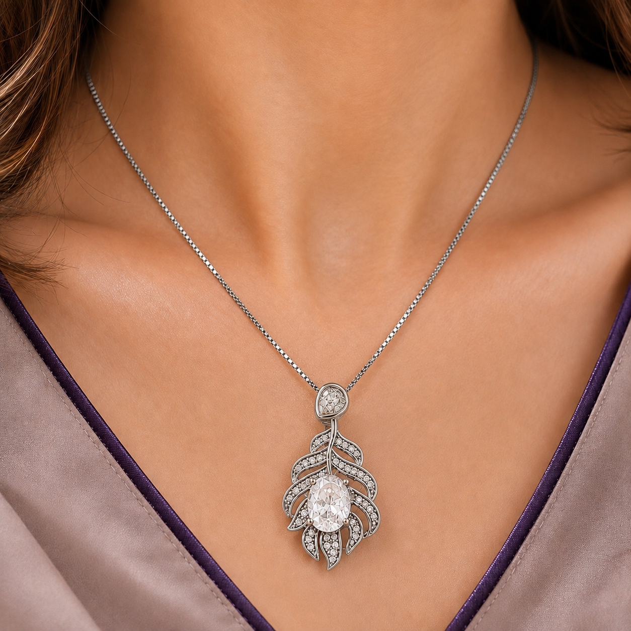 Model wearing the Plume Arc Pendant with a clear oval centre stone, layered zircon detailing and polished silver-tone finish