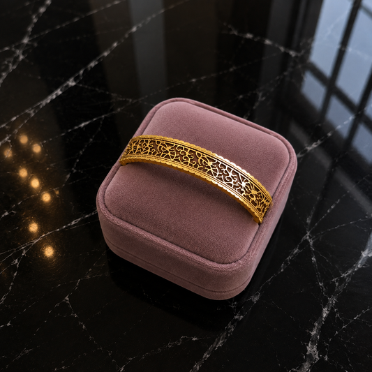 Gilded Lattice Cuff displayed on a mauve jewellery cushion with detailed gold-tone patterned finish