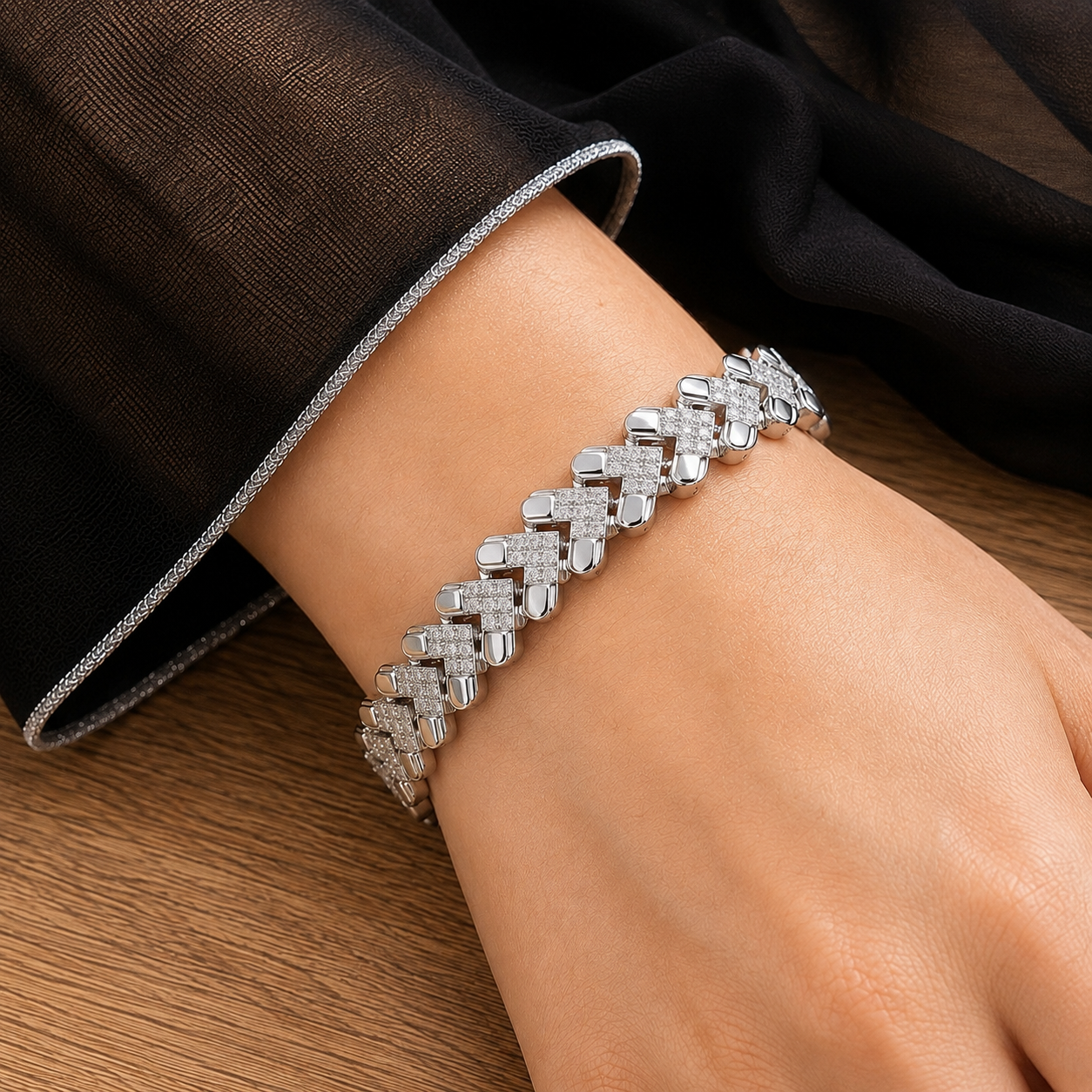 Close-up of Riven Link bracelet worn on the wrist, showing alternating polished silver-tone and zircon-set geometric links.