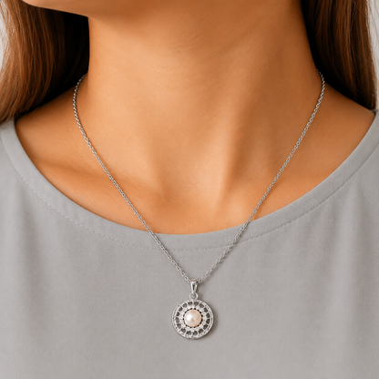 Close-up of the Solenne Pearl Pendant worn on a delicate chain, showing its luminous pearl centre, clear zircon detailing and circular openwork frame.