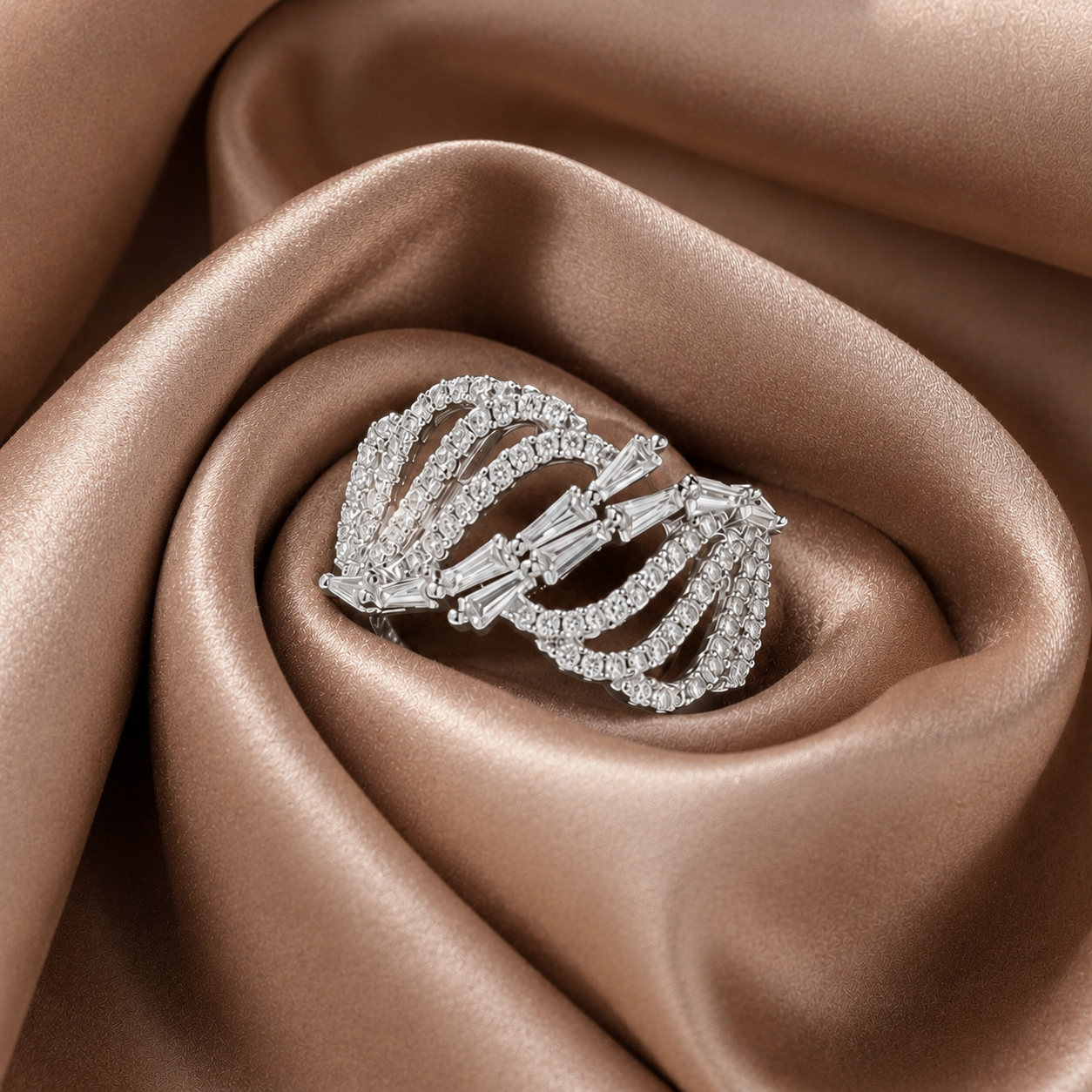 Arcveil silver-tone ring with layered zircon arcs and baguette-cut centre stones displayed on light brown satin.