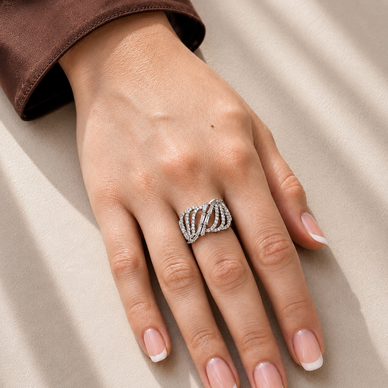 Close-up of Arcveil statement ring worn on hand, featuring sweeping clear zircon curves and baguette-cut accent