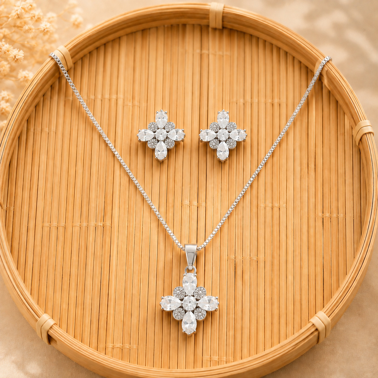 Silver-tone pendant and matching earrings with clear marquise stones displayed on a natural bamboo tray.