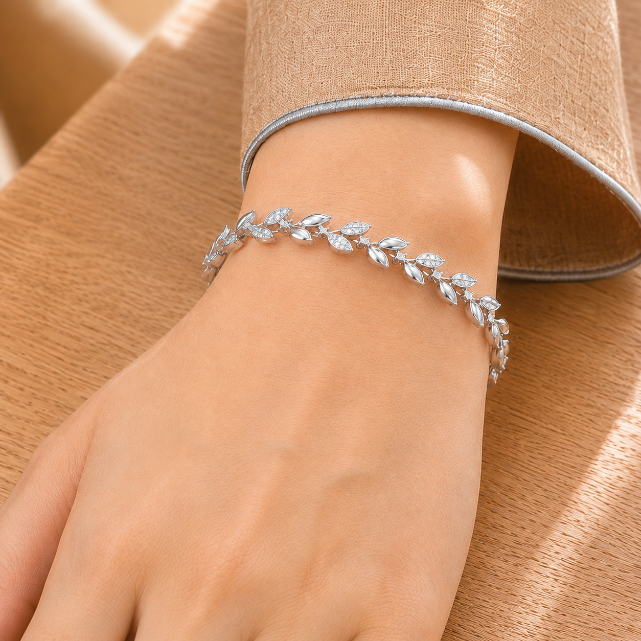 Close-up of Silver Sylvan Bracelet worn on wrist, showing polished leaf links and clear zircon detailing.