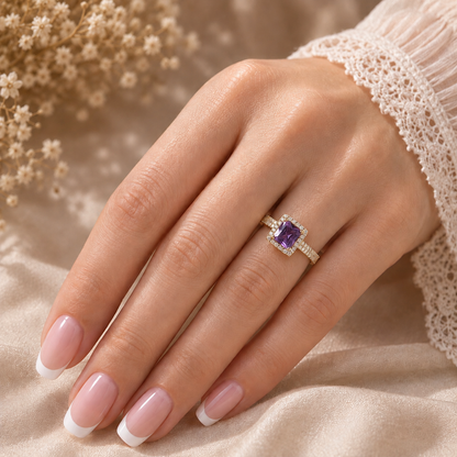  Amethyst  Purple Square-cut statement ring worn on a manicured hand, showcasing the faceted centre stone, sparkling halo and stone-set band
