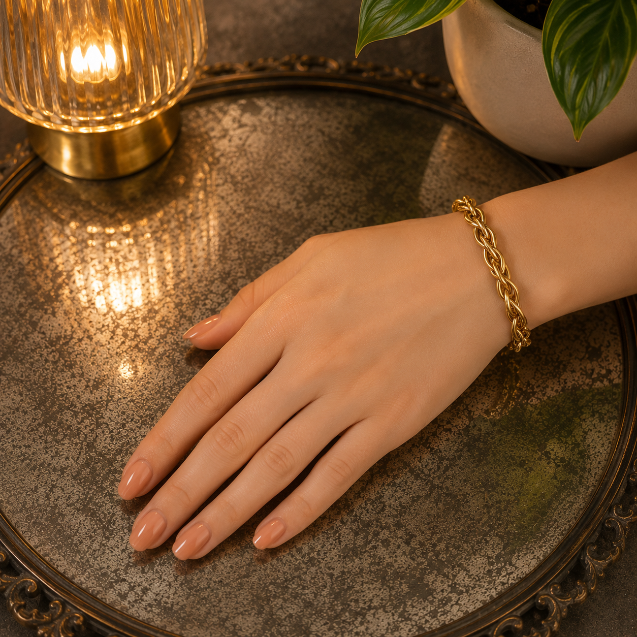 Close-up of a polished gold braided open cuff bracelet highlighting the woven texture and rounded end caps.