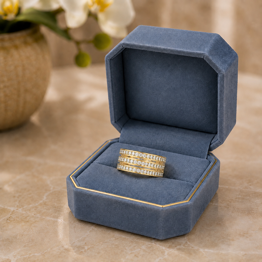 Lumen Trio light gold stainless steel crystal band ring displayed in a blue jewellery box