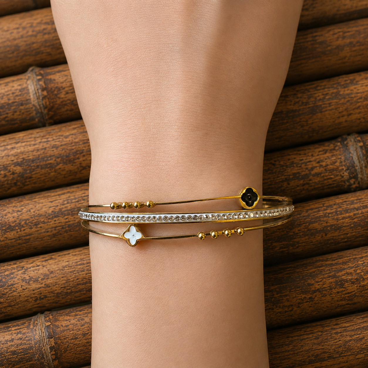 Close-up of a gold clover lock bracelet worn on the wrist with sparkling zircon detailing.