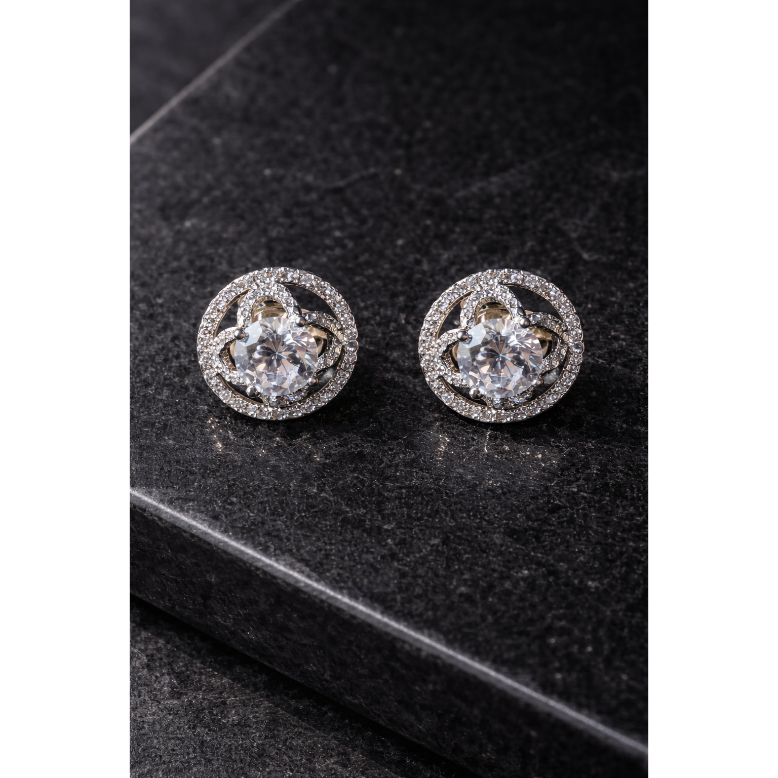 TIAS crystal halo stud earrings displayed on black stone surface in high-definition luxury jewellery styling.
