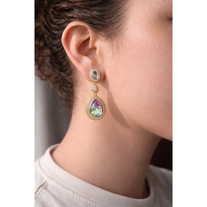 Model wearing light gold drop earrings with iridescent crystals, highlighting iridescent colours and pavé detailing in a high-fashion jewelry style.